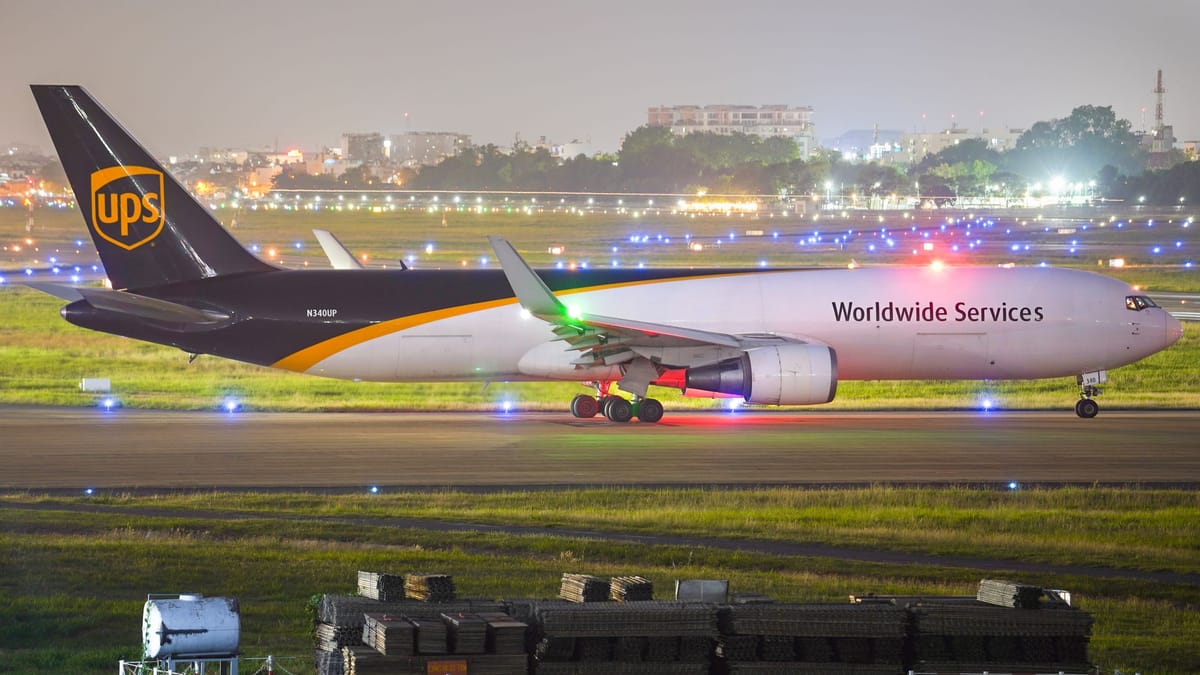 UPS Boeing 767 freighter with Worldwide Services livery taxiing on an airport runway at night